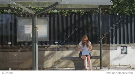 Lonely Young Girl Waiting At Bus Stop With Smart Phone In Blue Skirt
