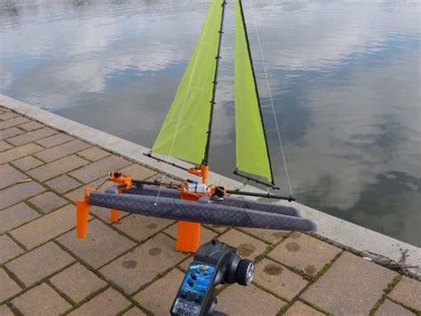 A Sailboat Sitting On The Side Of A Body Of Water Next To A Fire Hydrant