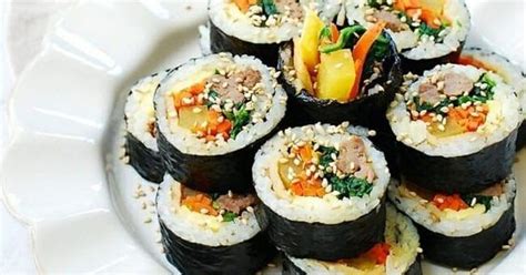To assemble, place a sheet of nori seaweed onto a sushi rolling mat lined with saran wrap. Gimbap (Korean dried seaweed rice rolls)