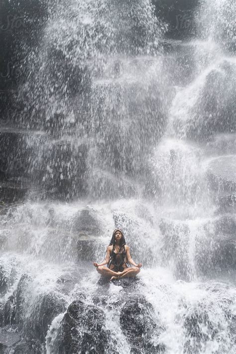 Young Woman Wearing Swimsuit Posing In Lotus Pose Under Waterfall By Stocksy Contributor Nick