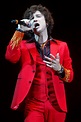 a man in a red suit singing into a microphone