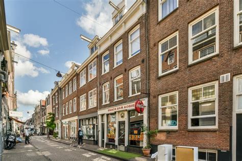 A City Street With A Red Brick Building With Shops Editorial