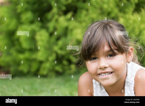Closeup Portrait Of The Smiling Beautiful Little Girl Lying On The