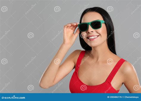 Beautiful Woman Wearing Sunglasses On Grey Background Stock Photo