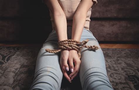 Mãos De Uma Mulher Vítima Amarrada Com Corda Foto Premium