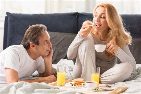 mature man looking at beautiful woman eating pancakes in bed stock image image of friendship