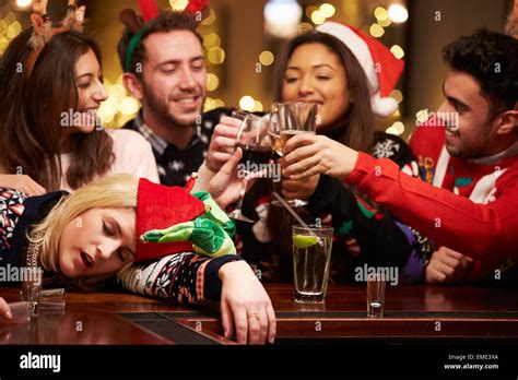 Woman Passed Out On Bar During Christmas Drinks With Friends Stock