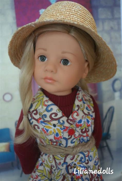 A Doll With Blonde Hair Wearing A Hat And Dress