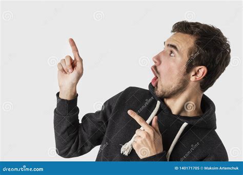 Shocked Caucasian Young Man Pointing And Looking Upwards Isolated On