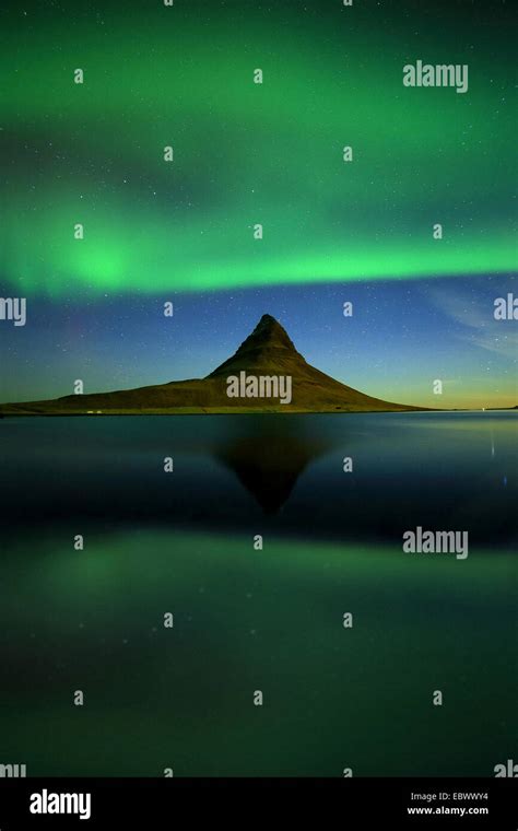 Kirkjufell Mountain By Night That Reflecting In The Sea With The Aurora