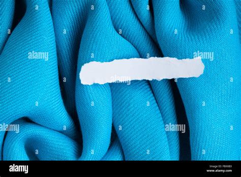 Blank Scrap Of Paper On Blue Cloth Wavy Folds Textile Background Stock