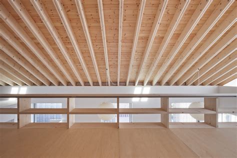 One option as part of a home remodel is to leave the roof rafters exposed by not installing a ceiling. facet studio pitches majestic M house roof with timber rafters