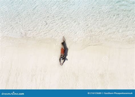 Top View Of Woman In Red Swimsuit And Relaxed Lying On Sand During Summer Vacation Which Under