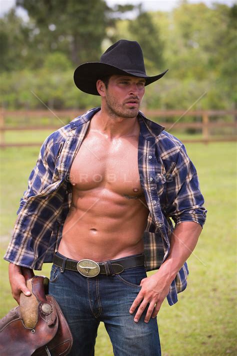 Cowboy With An Open Shirt Carrying A Saddle On A Ranch Rob Lang