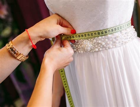 El Intentar Femenino En El Vestido De Boda En Una Tienda Con Las