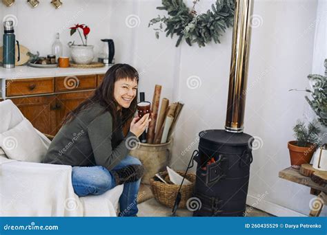 Back View Photo Of Woman Sitting Near Potbelly Stove At Home Female