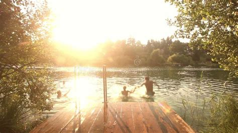 Couple Kissing And Jumping Into Water From River Dock Stock Footage
