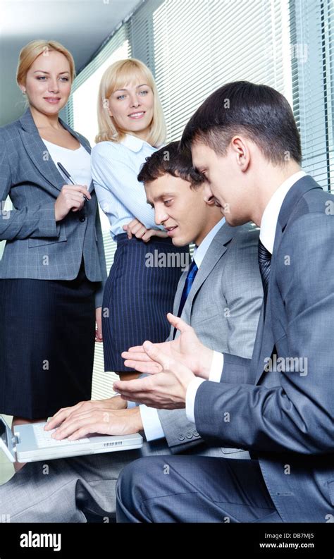 Two Businessmen Interacting While Working With Laptop On Background Of