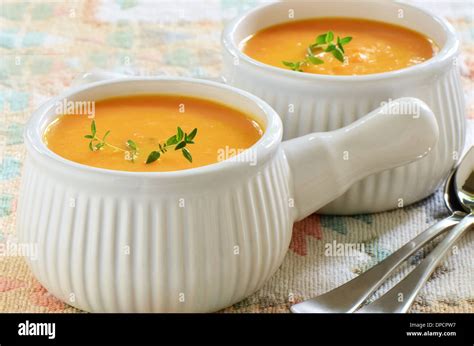 Creamy Carrot And Sweet Potato Soup With Sprig Of Thyme In White Ribbed