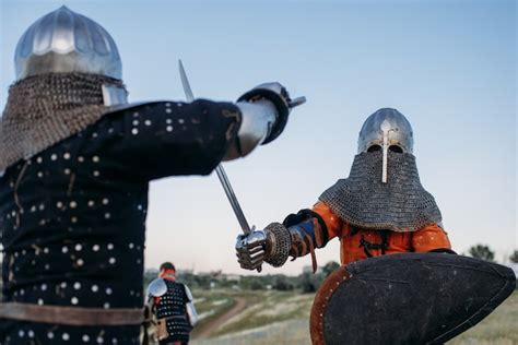 Premium Photo Medieval Knights In Armor And Helmets Fight With Sword