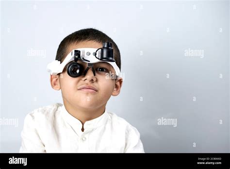 Little Boy Looking Through Special Magnifying Eyeglasses Stock Photo