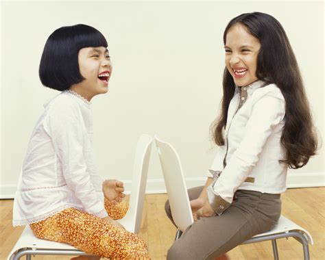 Foto Gratis Two Young Girls Sit Face To Face On Chairs Giggling Para