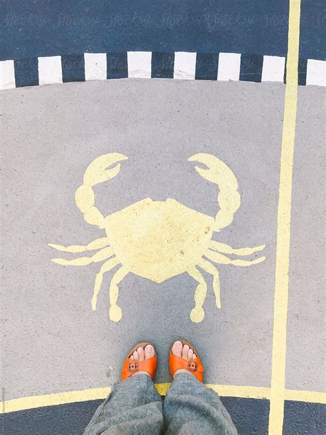 Looking Down In A Woman S Feet Wearing Orange Sandals Standing In Front Of A Painted Crab By