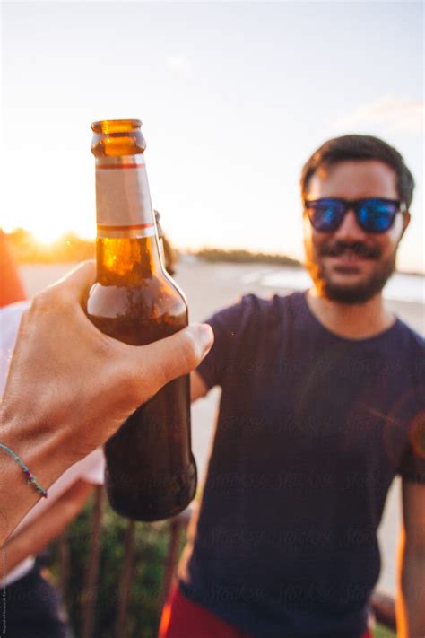 Pov Shot Of A Man Toasting A Bottle Of Beer With A Friend On The Beach