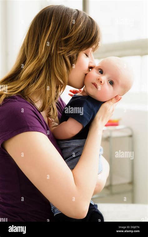 Mother Kissing Baby Son On Cheek Stock Photo Alamy