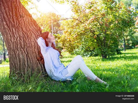 Girl Sitting Against Tree