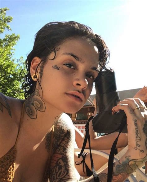 A Woman With Tattoos Is Taking A Selfie