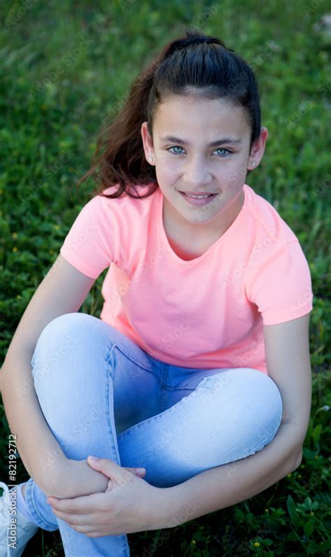 Preteen Girl With Blue Eyes Sitting On The Grass Stock Photo Adobe Stock