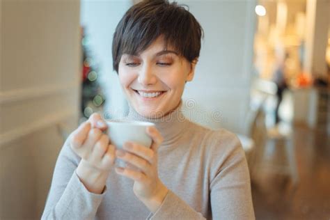 Woman Holding Cup And Drinking Coffee In The Morning In Cafe During
