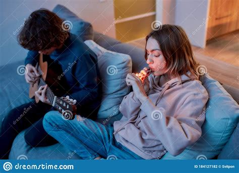 Friends Or Couple Smoking Weed Young Girl Lighting Cannabis In The Glass Bong Relaxing With