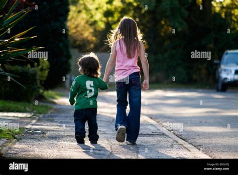 Two Lost Children Walking Down A Road Stock Photo Alamy