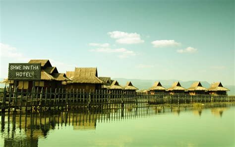 A Row Of Huts Sitting On Top Of A Body Of Water