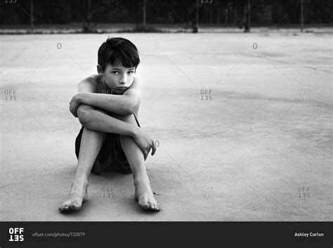 Boy Sitting Alone On Ground Stock Photo Offset