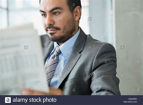 Businessman Reading Newspaper In Office Building Stock Photo Alamy