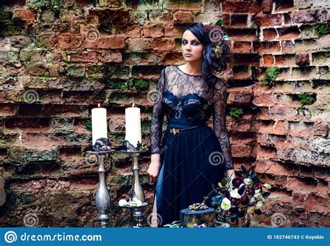 A Girl In A Mystical Dark Image In A Black Dress With Flowers In Her Hair Against The Background