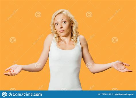 Blonde Woman Showing Shrug Gesture Isolated On Orange Stock Photo Image Of Attractive