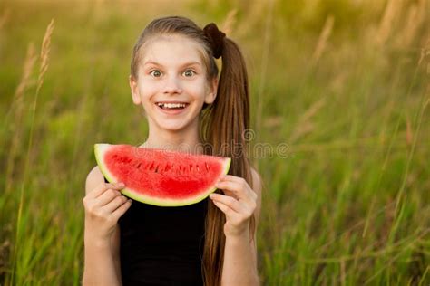 Funny Kid Girl Eating Watermelon Outdoors In Summer Park Stock Image