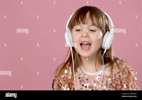 Pretty 6 Or 7 Years Old Little Girl Singing And Dancing With Headphones