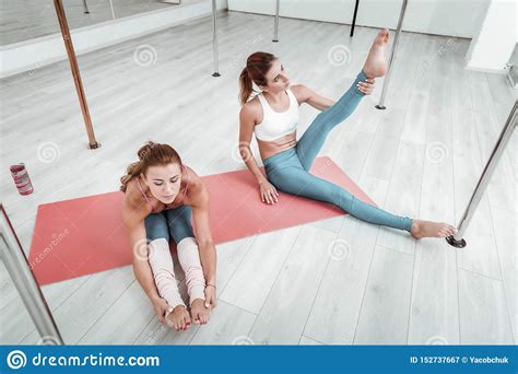 Two Women Stretching Together On A Mat Stock Image Image Of Calmness