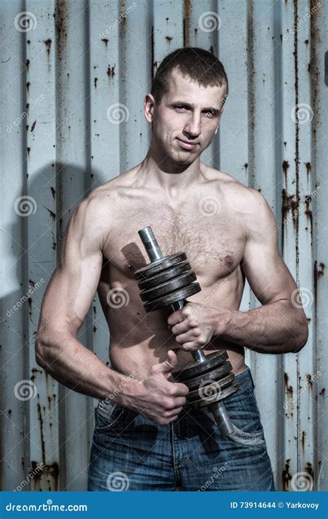 Young Athletic Man Doing Sport Exercises With Dumbbell Stock Photo