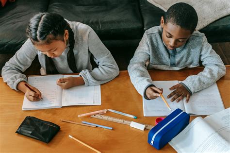 Focused Children Doing Homework At Table · Free Stock Photo