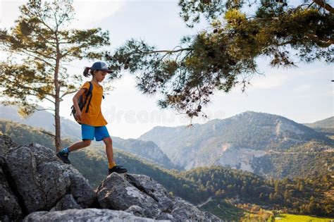 Adventure And Travel A Little Boy With A Backpack Walks Along A Forest