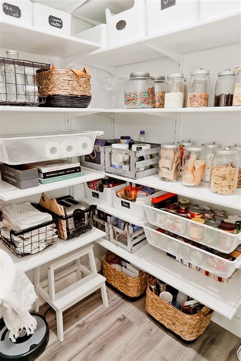 an organized pantry with baskets food and other items on shelves in the center of the room