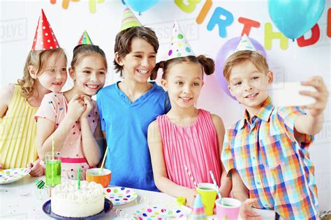 Row of happy kids making selfie at birthday party - Stock Photo - Dissolve