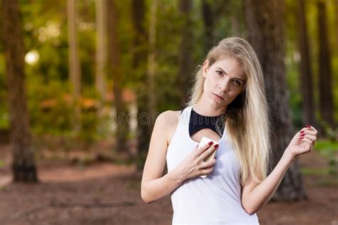 Beautiful Blond Young Woman In Park At Sunset Holding Mobile Near Chest Image Stock Image