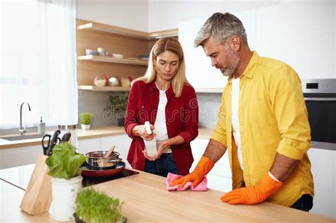 Senior Couple Cleaning Table Caring Guy And His Wife Wiping Kitchen